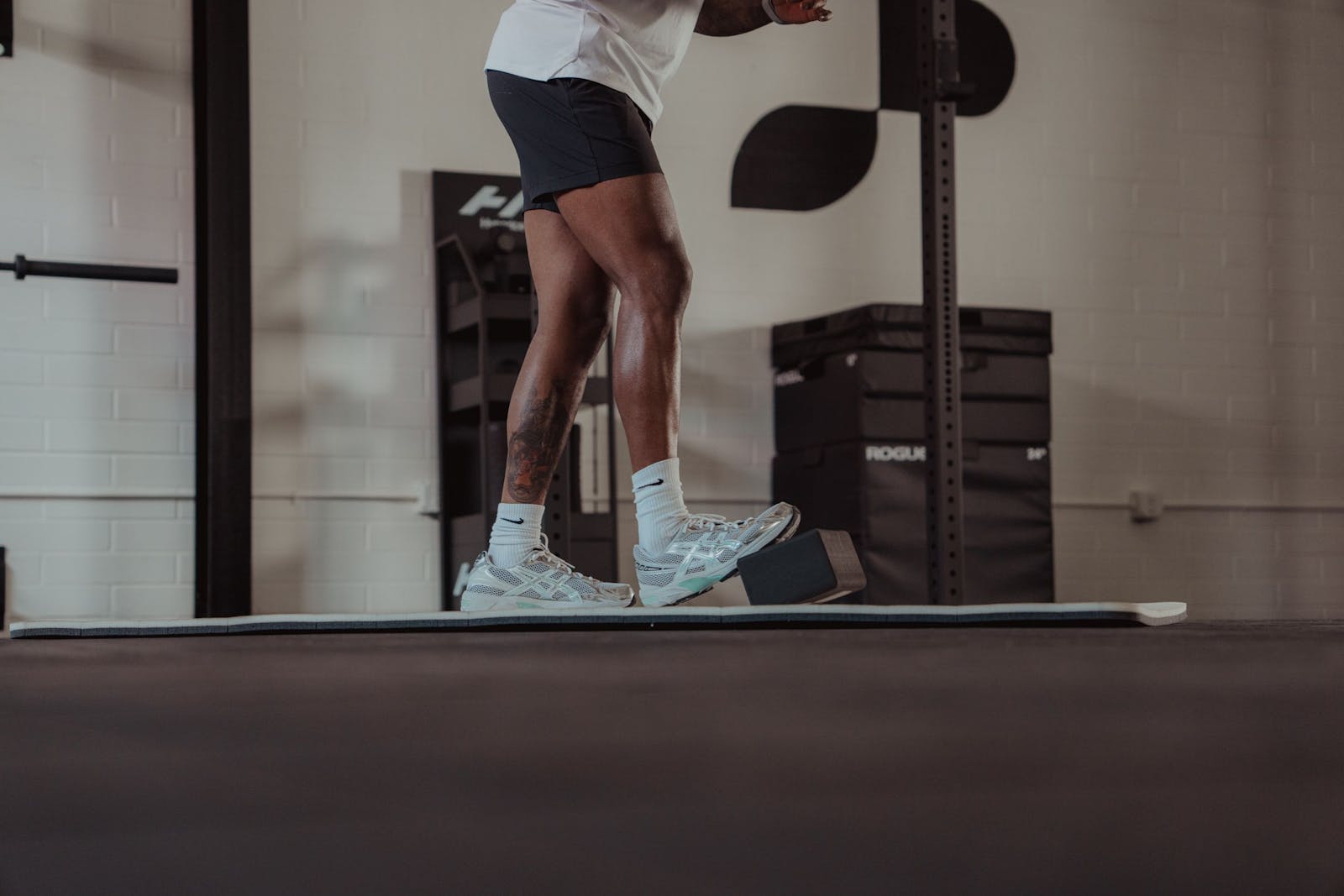 Athlete balancing on a board in a gym, training control through their active range of motion